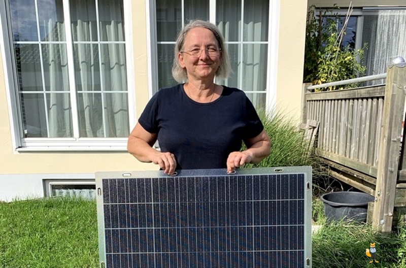 Plugin Energy AIR Superlight Solarmodul in transparent wird von einer Frau mit zwei Fingern gehalten.